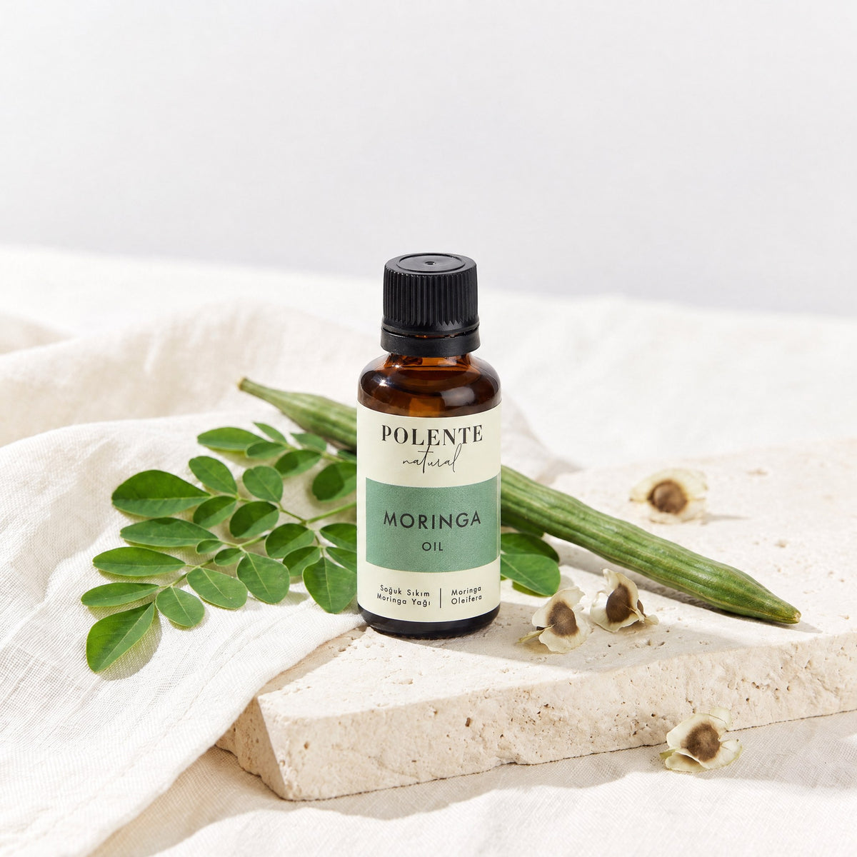 Moringa Yağı Soğuk Sıkım 30 ml — moringa yaprakları ve tohumlarıyla botanik konsept görseli