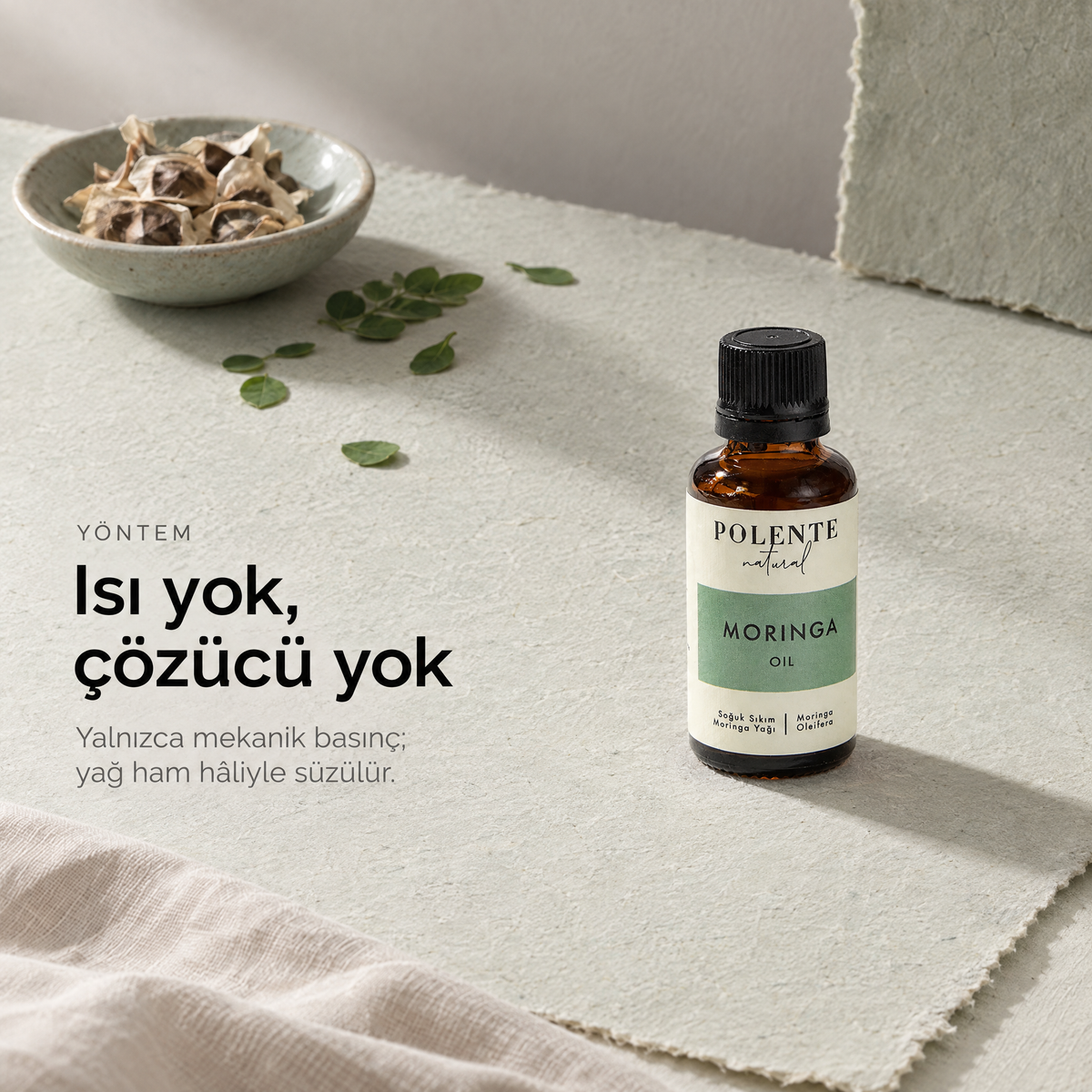 Moringa Yağı 30 ml — soğuk sıkım çalışma masası, şişe ve hammadde üstten görünüm