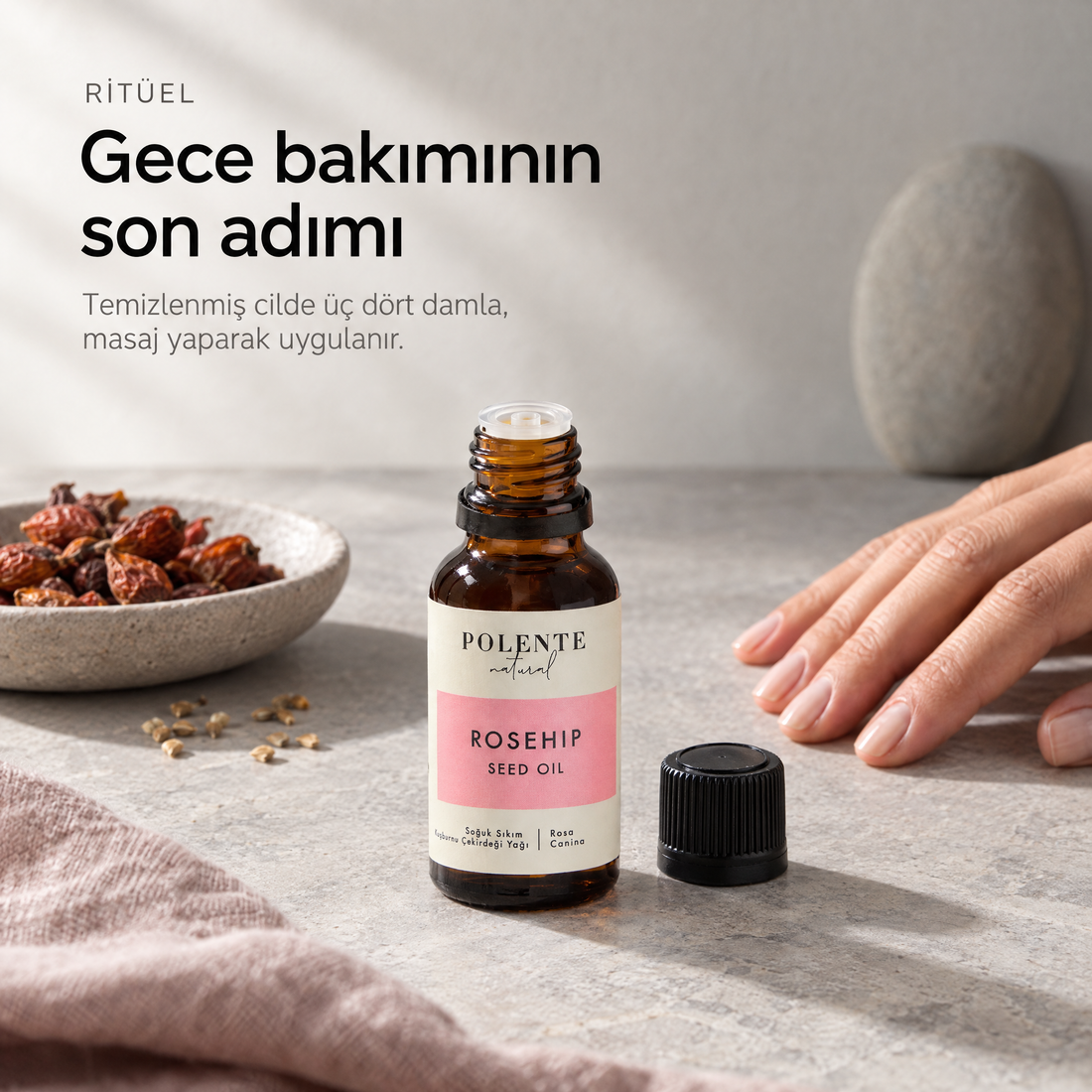 Kuşburnu Çekirdeği Yağı 50 ml — sabah ritüeli, kapağı açılmış cam şişe yanında duran el