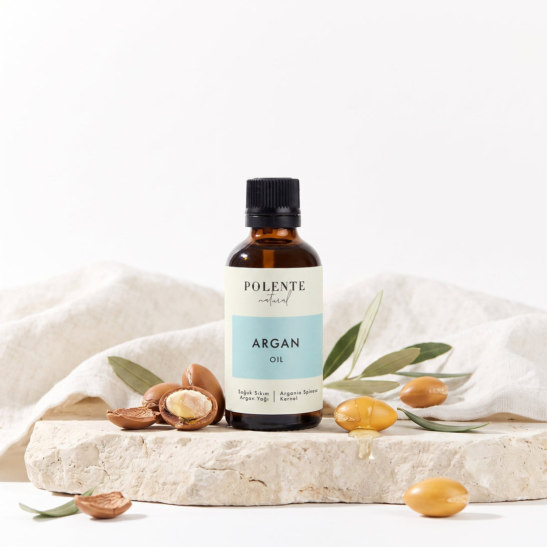 Argan Yağı Soğuk Sıkım 50 ml — argan çekirdekleri ve yapraklarıyla botanik konsept görseli