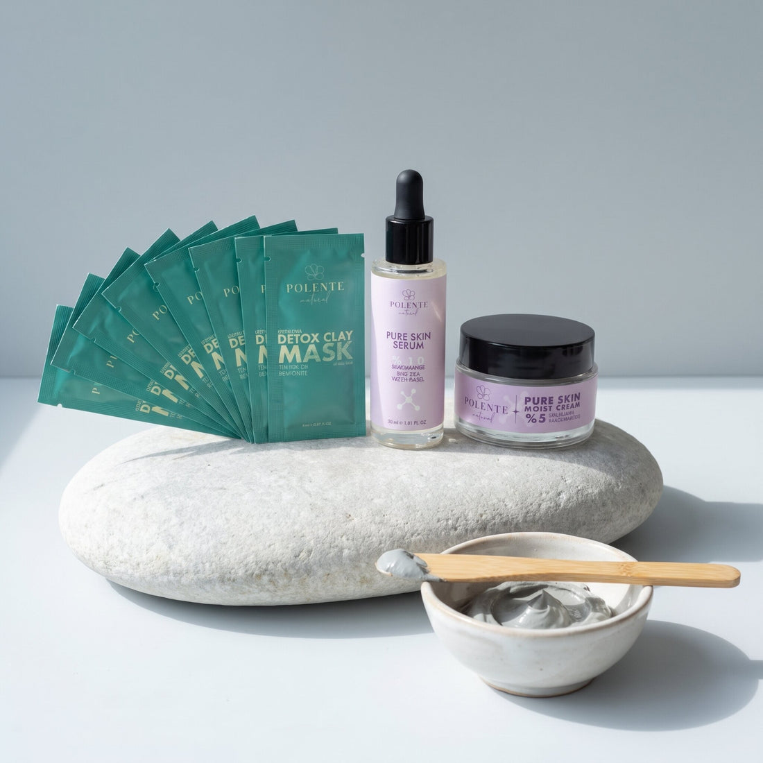 Detoks Kil Maskeli Pure Skin Cilt Bakım Seti — gri nehir taşında seramik kâsede kil ve bambu spatula ile spa konsept görseli