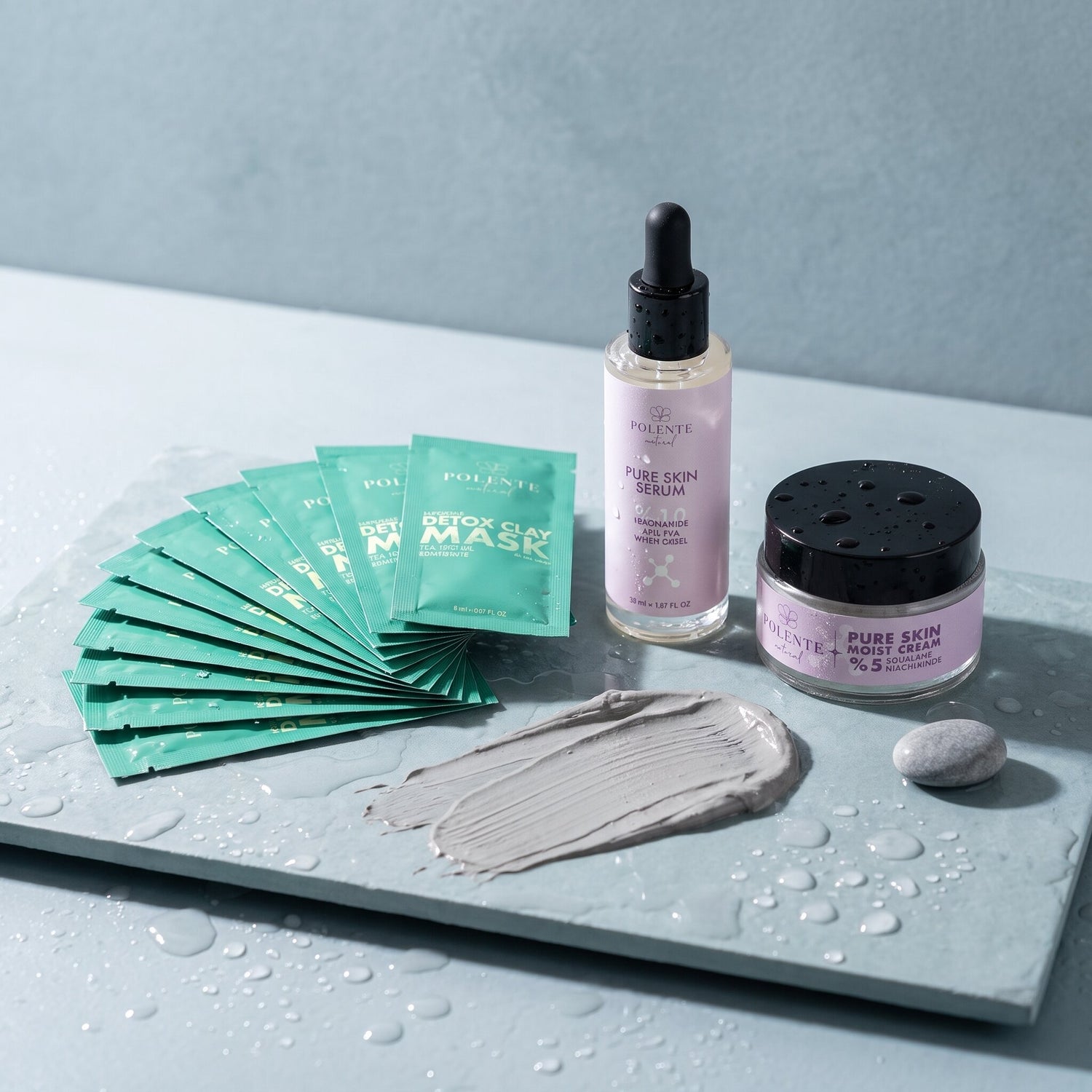 Detoks Kil Maskeli Pure Skin Cilt Bakım Seti — ıslak arduvaz üzerinde kil maske sürtüsü ve su damlacıklarıyla konsept görseli