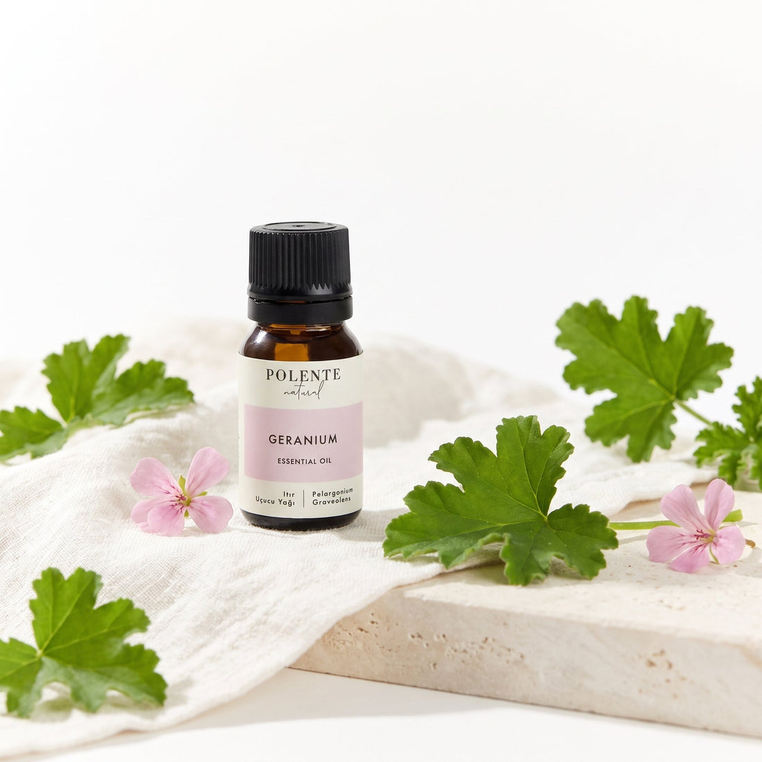 Itır Uçucu Yağı 10 ml — ıtır yaprakları ve pembe çiçekleriyle botanik konsept görseli