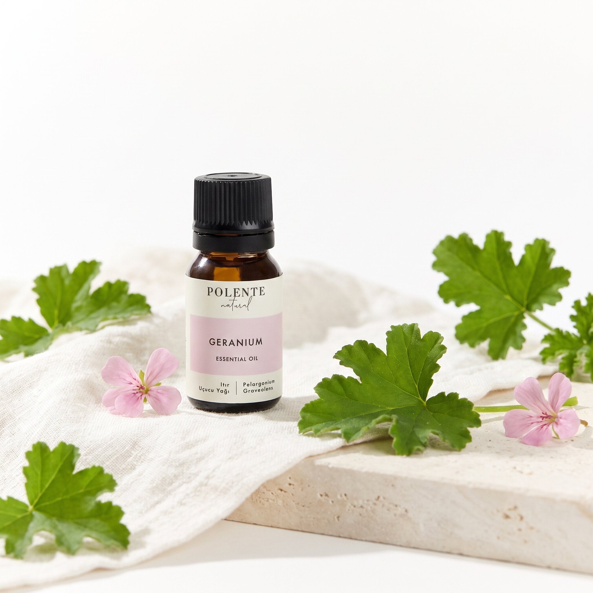 Itır Uçucu Yağı 10 ml — ıtır yaprakları ve pembe çiçekleriyle botanik konsept görseli