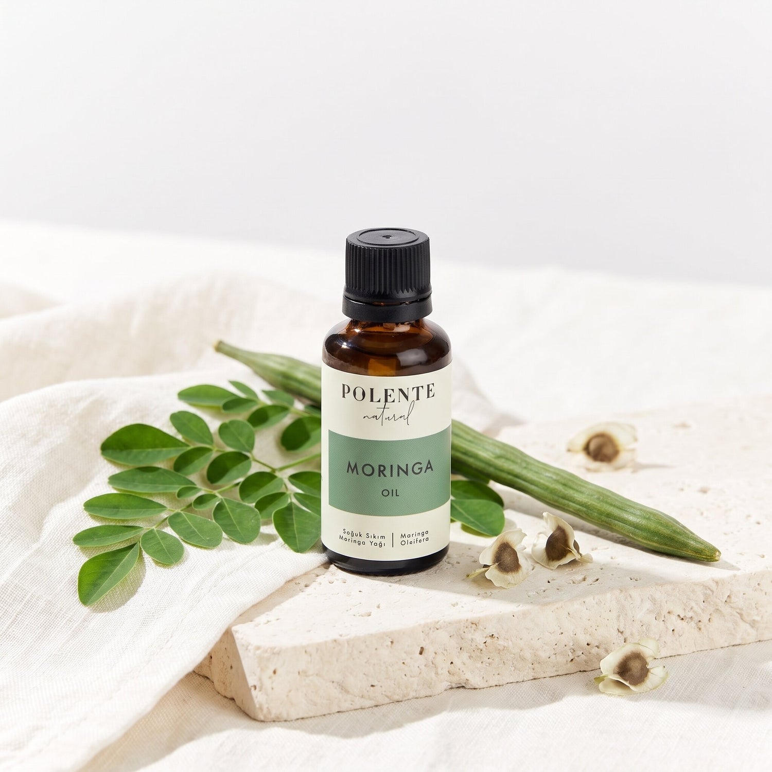 Moringa Yağı Soğuk Sıkım 30 ml — moringa yaprakları ve tohumlarıyla botanik konsept görseli